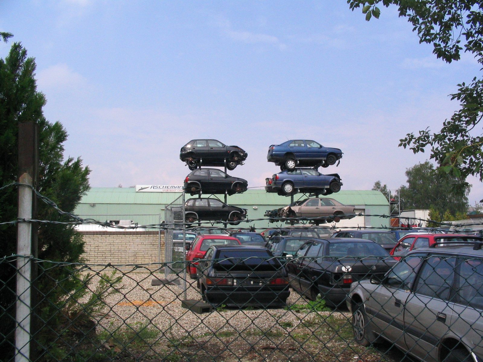 Ein Schrottplatz mit übereinandergestapelten Autos