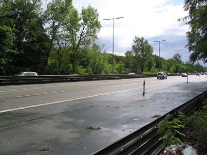 Die nasse, mehrspurige Avus mit Leitplanke, links Wald