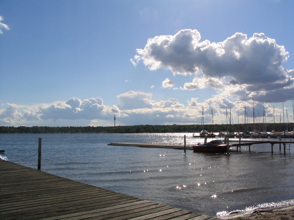Ein Holzsteg am Wannsee, dahinter Segelboote mit kahlen Masten